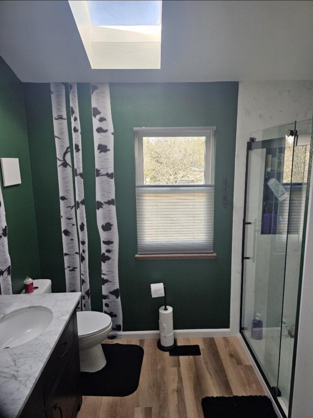 Remodeled bathroom with glass shower and green walls